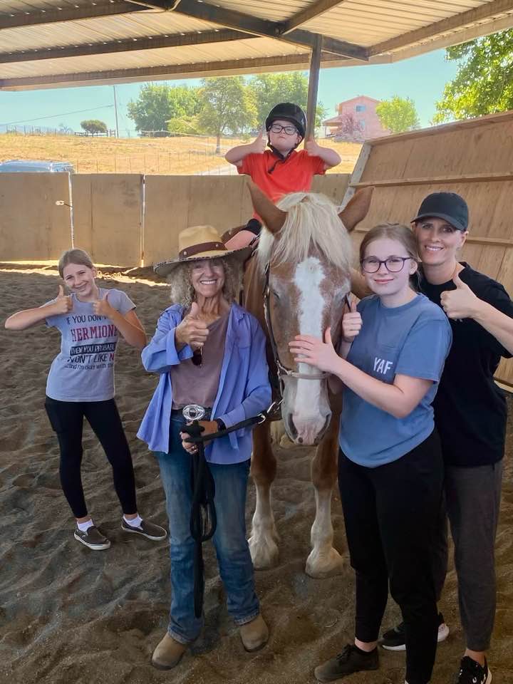 Family with a horse during an equine-assisted family and group session at Warrior's Soul.